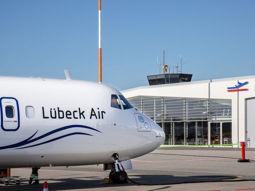 Flugzeug steht vor Terminal des Lübecker Flughafens