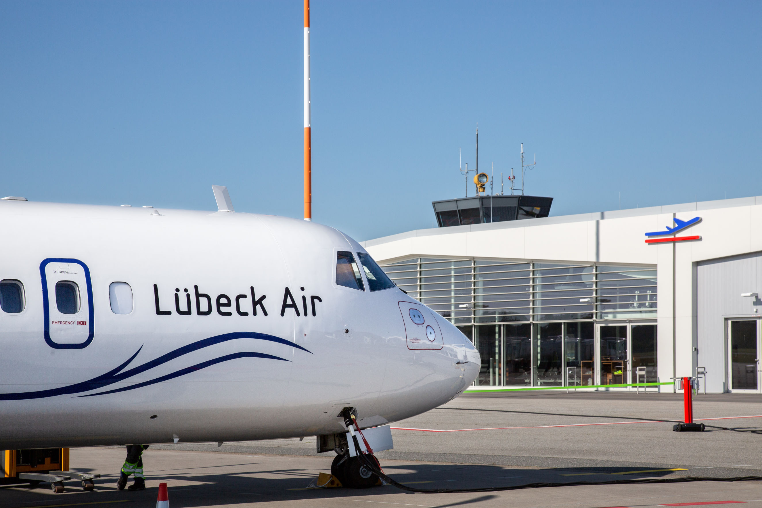 Flugzeug steht vor Terminal des Lübecker Flughafens